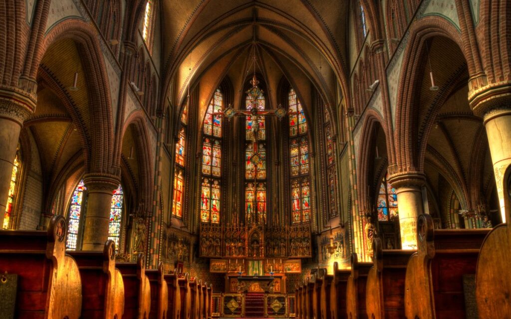Intricate architecture of a historic church interior with stained glass windows.