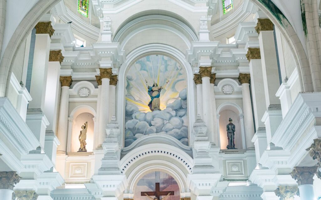 Detailed view of a basilica interior showcasing ornate architecture and religious artworks.
