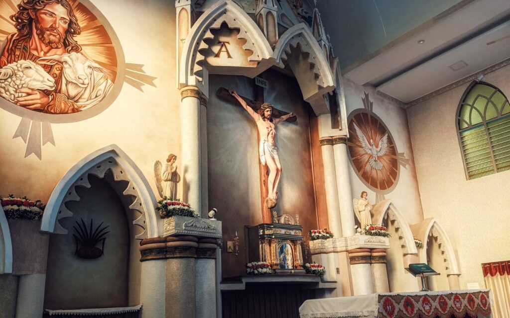 A detailed view of a church altar featuring a crucifix and religious icons in a serene indoor setting.