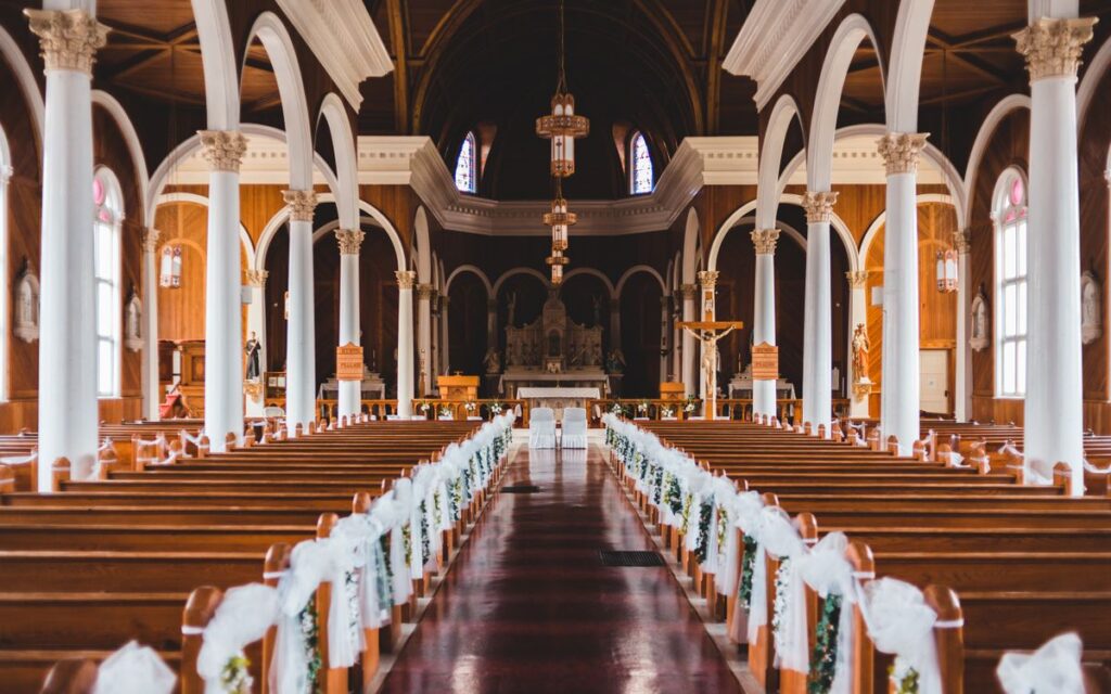 Elegant view of a church interior with decorated pews and arches, highlighting its architectural beauty.