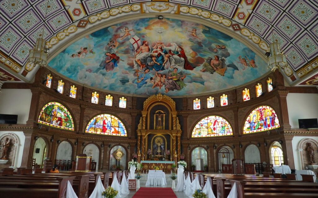 Explore the detailed interior of a Catholic church featuring stained glass and ornate religious artwork.
