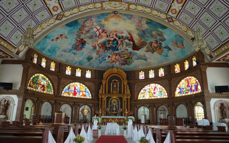Explore the detailed interior of a Catholic church featuring stained glass and ornate religious artwork.